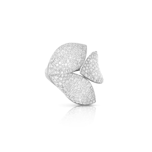 May include: A silver ring featuring a three-petal design, each petal covered in small, sparkling stones. The ring is set against a white background, with a subtle reflection visible below.