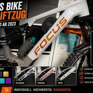 Könnte beinhalten: Weißes und oranges Focus Fahrradrahmen-Aufkleber-Set. Das Bild zeigt einen weißen Fahrradrahmen mit dem Wort "FOCUS" in Orange. Der Text auf dem Bild lautet "Custom Dein Design Deine Farbe" und "2 Stück Set Für Unterrohr".