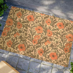 Op de afbeelding: Een rechthoekige deurmat met een herhalend patroon van oranje klaprozen en groene bladeren op een beige achtergrond. Het bloemmotief bedekt het gehele oppervlak van de mat en creëert een uitnodigende entree.