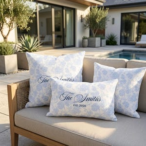 May include: Three throw pillows with a light blue and white floral pattern. Two square pillows and one rectangular pillow feature the dark blue cursive text "The Smiths" printed on the front, with the rectangular pillow also displaying "EST. 2026".
