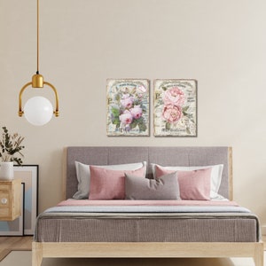 Op de afbeelding: Twee ingelijste bloemenprints met roze rozen en groene bladeren op een witte achtergrond. De prints bevatten Franse tekst en worden boven een bed met roze en grijze kussens weergegeven.
