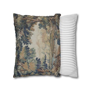 May include: Two decorative pillows. One square pillow features a tapestry design with a forest scene in shades of green, blue, and brown. The second pillow is a long, rectangular shape with gray and white stripes.