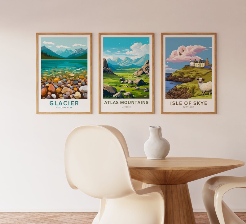 Op de afbeelding: Drie ingelijste landschapsprints. De prints tonen schilderachtige uitzichten op Glacier National Park, Atlas Mountains en Isle of Skye. Elke print heeft een houten lijst en tekst ter identificatie van de locatie. De kunststijl is een kleurrijke, gestileerde illustratie.