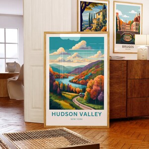 May include: A framed poster with a colorful illustration of a winding road through a valley with a river and a small house. The text "HUDSON VALLEY NEW YORK" is at the bottom of the poster.
