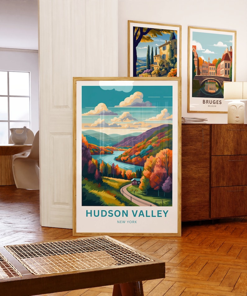 May include: A framed poster with a colorful illustration of a winding road through a valley with a river and a small house. The text "HUDSON VALLEY NEW YORK" is at the bottom of the poster.