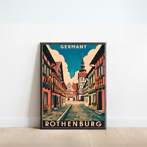 Può includere: Un poster vintage di viaggio con un'illustrazione colorata di una strada acciottolata a Rothenburg, in Germania. Il poster ha il testo "GERMANY" e "ROTHENBURG" in un font retrò.