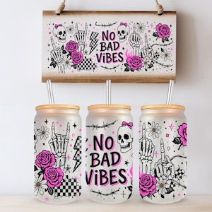 May include: Frosted glass tumblers with bamboo lids and metal straws. Each tumbler features a unique design with skulls, roses, and the text "NO BAD VIBES". The design includes a checkerboard pattern, lightning bolts, and hand gestures. A matching wooden sign hangs above.