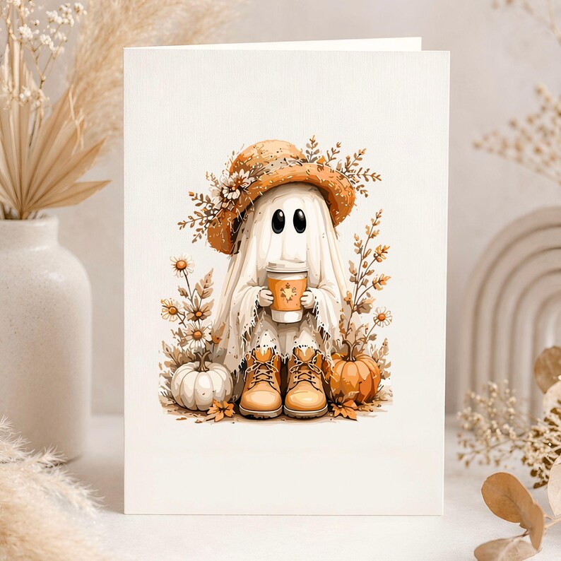May include: A greeting card featuring a whimsical ghost character. The ghost wears a straw hat adorned with flowers and holds a coffee cup. The illustration includes pumpkins, boots, and fall foliage, creating a seasonal theme.
