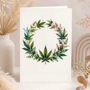 Peut inclure: Une carte de v&oelig;ux rectangulaire pr&eacute;sentant une illustration de couronne circulaire compos&eacute;e de feuilles de cannabis vertes. L'&oelig;uvre utilise des touches de style aquarelle bleu et rose sur un fond blanc cass&eacute; uni.