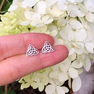 May include: A pair of silver Celtic knot earrings. The earrings are in the shape of a triangle with a knot design.