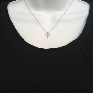 Puede incluir: Un collar de cadena de plata con un peque&ntilde;o colgante de lib&eacute;lula de cristal transparente.