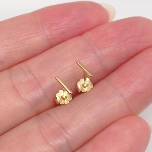 K&ouml;nnte beinhalten: Ein Paar goldene Bar-Ohrstecker. Die Ohrringe sind schlicht und minimalistisch, mit einem geraden Barren-Design.