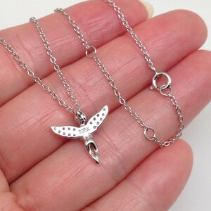 Puede incluir: Un collar de cadena de plata con un peque&ntilde;o colgante de &aacute;ngel. El &aacute;ngel tiene alas con peque&ntilde;as piedras transparentes y un halo. La cadena es una cadena de cable delicada.