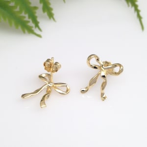 Puede incluir: Un par de pendientes de color dorado en forma de lazo. Los pendientes est&aacute;n hechos de metal retorcido y tienen un dise&ntilde;o simple y elegante.