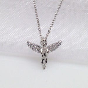 Puede incluir: Un collar de plata con un peque&ntilde;o colgante de &aacute;ngel detallado. El &aacute;ngel lleva un vestido y tiene alas con peque&ntilde;as piedras transparentes.