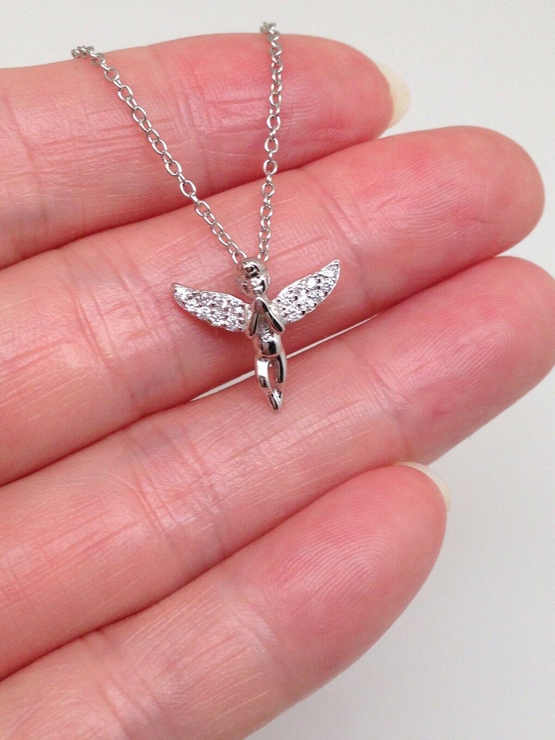 Puede incluir: Un collar de plata con un peque&ntilde;o colgante de &aacute;ngel detallado. El &aacute;ngel est&aacute; adornado con piedras de circonita c&uacute;bica transparentes.