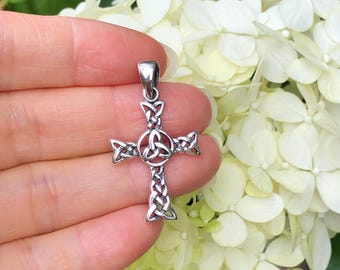 May include: A silver Celtic knot cross pendant. The cross is made of intertwined knots, creating an intricate design.