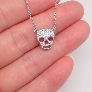 Puede incluir: Un collar de cadena de plata con un peque&ntilde;o colgante de calavera incrustado con circonitas c&uacute;bicas.