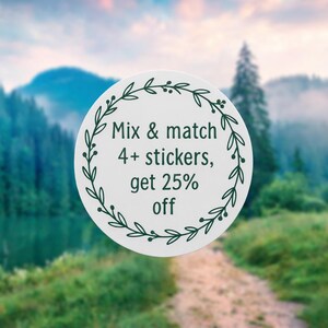 May include: A white circular sticker with dark green text and a decorative leaf border. The text reads "Mix & match 4+ stickers, get 25% off". The background is a blurred image of a forest and a lake.