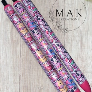 May include: Three pink pens with black tips and pink ink tips. The pens are decorated with a repeating pattern of Disney characters in a comic book style. The pens are on a light wood surface. The text "MAK KREATIONS" is in the background.
