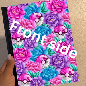 May include: Notebook with a floral design featuring pink, purple, and blue flowers, along with pink and white patterned spheres. The words "Front side" are printed in white across the front of the notebook.