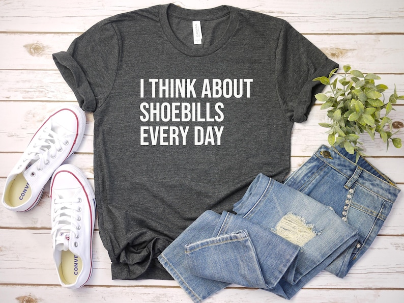 May include: A dark gray t-shirt with white text that reads "I think about shoebills every day".