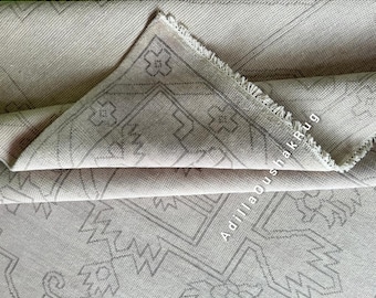 May include: A close-up of a light gray rug with a geometric pattern. The rug has a fringe border and the text "Adillla Oushak Rug" is visible in the lower right corner.