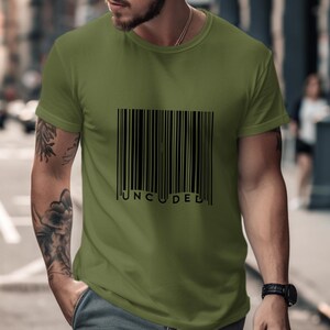 Op de afbeelding: Een groen T-shirt met een zwarte barcode-afbeelding en het woord "UNCODED" eronder gedrukt.