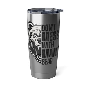 May include: A stainless steel travel mug with a gray finish. The mug features a black and white illustration of a bear's head with the text "Don't Mess With Mama Bear".