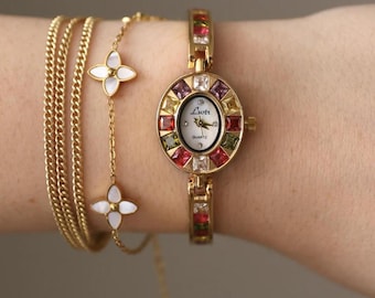 Reloj de oro con piedras preciosas, estilo vintage, elegante, art déco, minimalista, con pulsera.