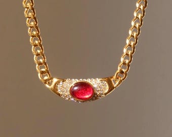 Collar gargantilla Art Déco vintage con gema roja y detalles de cadena dorada.