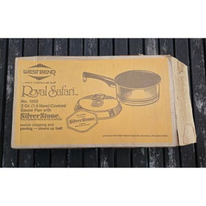 May include: A vintage West Bend Royal Safari saucepan box. The box is tan with a graphic of the pan and lid. Text includes "SilverStone" and "2 Qt. (1.9 litres) Covered Sauce Pan".
