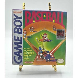 Op de afbeelding: Een Nintendo Game Boy videospel cartridge doos voor "Baseball". De doos bevat een honkbalveld illustratie met spelers en de speltitel in grote rode letters. De doos bevat ook de tekst "Hardball action voor 1 of 2 spelers."