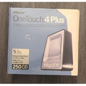 Puede incluir: Una caja de venta cuadrada para un disco duro externo Maxtor OneTouch 4 Plus. El embalaje es azul claro y blanco, con el nombre del producto, una capacidad de 250 GB, garantía limitada de 5 años y compatibilidad USB 2.0 y FireWire 400.