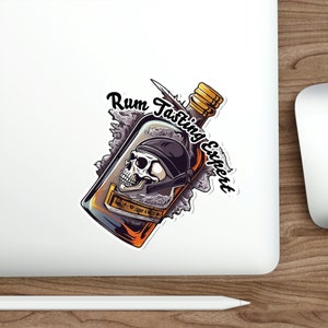 May include: A sticker featuring a cartoon illustration of a bottle of rum with a skull inside. The bottle is surrounded by a cloud of smoke and the text "Rum Tasting Expert" is written around the bottle.