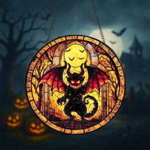 Op de afbeelding: Ronde Halloween-decoratie van glas-in-lood met een zwarte demon met rode ogen, hoorns en vleugels. Het ontwerp omvat een volle maan, vleermuizen en een spookachtige achtergrond met bomen en een kasteel. Hangt aan een zilveren ketting.
