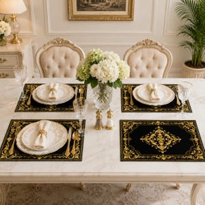 Peut inclure: Un service de table composé de quatre sets de table rectangulaires noirs avec des bordures en filigrane doré et un motif central doré. Chaque couvert comprend une assiette blanche, une serviette blanche pliée avec un rond de serviette doré.
