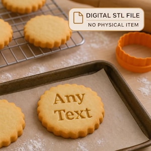 May include: A round, scalloped-edge cookie on a baking sheet with the words Any Text embossed in the center. Nearby are plain cookies on a wire rack, an orange plastic cookie cutter, and a text box stating DIGITAL STL FILE NO PHYSICAL ITEM.