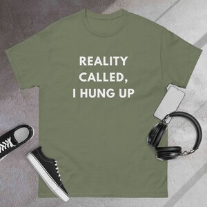 May include: A green t-shirt with the text "REALITY CALLED, I HUNG UP" printed in white.