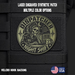 May include: A circular olive green and black synthetic patch with laser engraving. The design features a skeleton wearing a headset, computer monitors, and a mug labeled FUELED BY CALLS. Text reads DISPATCHER NIGHT SHIFT, 911, and SAME VOICES DIFFERENT NIGHT.