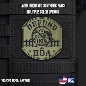 May include: An olive green laser engraved synthetic patch with a hook backing. The patch features a house graphic with a slash through it, a picket fence, and the text DEFUND the HOA. Above the patch is text reading LASER ENGRAVED SYNTHETIC PATCH MULTIPLE COLOR OPTIONS.