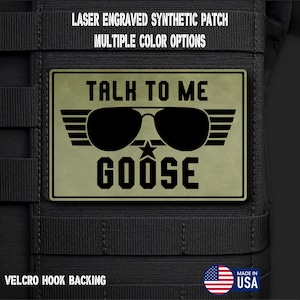 May include: A rectangular olive green synthetic patch with black laser-engraved text reading TALK TO ME GOOSE. The design features black aviator sunglasses with wings and a small star. The patch includes text stating LASER ENGRAVED SYNTHETIC PATCH, MULTIPLE COLOR OPTIONS, and VELCRO HOOK BACKING.