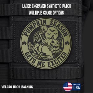 May include: A circular olive green laser engraved synthetic patch with a hook backing. The design features a skeleton, a jack-o'-lantern, bats, and the text PUMPKIN SEASON GETS ME EXCITED. The patch is attached to a black tactical gear surface.