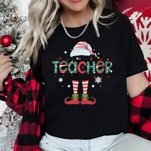 May include: Black t-shirt with a Christmas elf design and the word "teacher" in green and red letters.