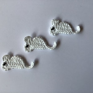 Op de afbeelding: Drie witte gehaakte muizen met zwarte ogen. De muizen zijn in een rij gerangschikt, met de staarten naar rechts wijzend.
