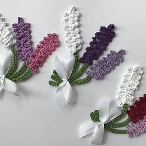 Peut inclure: Des brins de lavande crochetés en blanc, violet et rose, noués avec des rubans de satin blancs. Les tiges sont vertes. Ces éléments floraux faits à la main sont parfaits pour les travaux manuels ou la décoration.