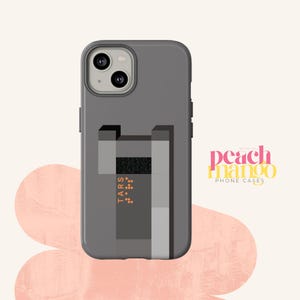 May include: A gray phone case with a geometric design featuring a black rectangle with the word "TARS" and a pattern of small dots. The case is designed for an iPhone with a camera bump.
