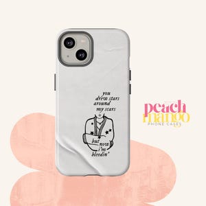 May include: White phone case with a black graphic of a person with stars and the text "you drew stars around my scars but now I'm bleedin'". The Peach Mango logo is in the bottom right corner.