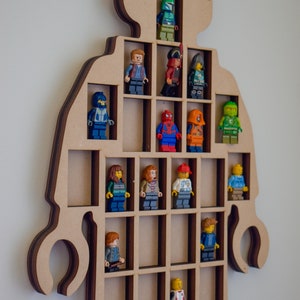 May include: A light brown wooden display rack shaped like a human figure with claw-like hands, featuring multiple rectangular compartments. Various colorful plastic minifigures are positioned within the individual slots of the grid structure.