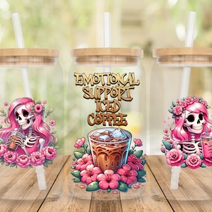 May include: Three clear glass tumblers with bamboo lids and straws. Each tumbler features a pink and black skull with flowers and the text "Emotional Support Iced Coffee".